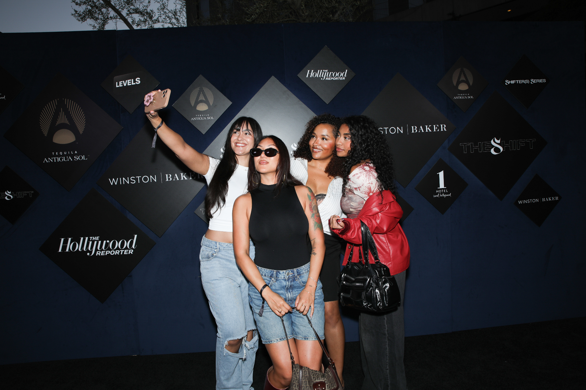 Guests taking a selfie on the Shifter(s) Series step and repeat