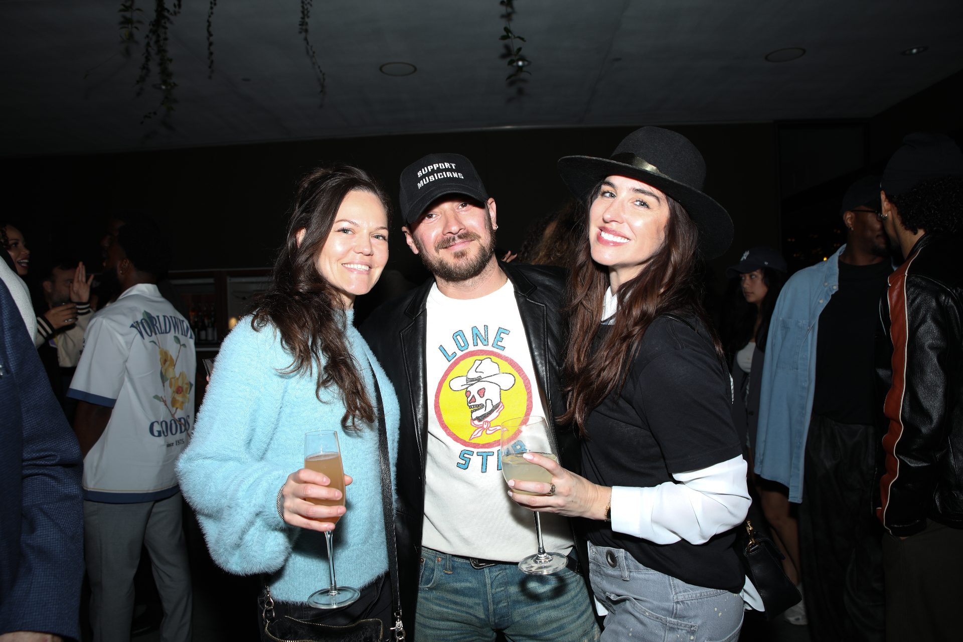Three guests raising a glass together at the Rhythm Garden after party